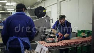 一个穿制服的员工<strong>正在准备</strong>生产香肠。熏香肠店