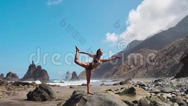 穿着紧身衣的年轻<strong>女子</strong>在令人惊叹的日出时在海面上的海滩上练习<strong>瑜伽</strong>。 健身、运动、<strong>瑜伽</strong>和健康