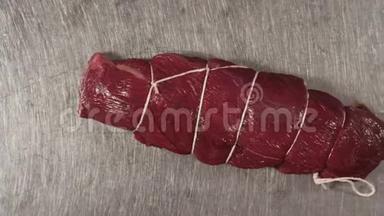 一块新鲜的红肉的特写镜头。场景。用食物绳绑住的一块肉的俯视图