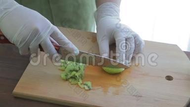 一个女人用一把刀在木板上切奇异果。 摄像机从左向右移动。