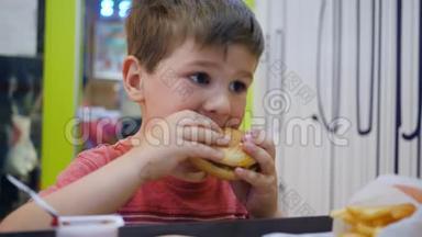 小男孩在<strong>儿童餐</strong>厅吃饭时胃口大开，漂亮的宝宝在吃饭，孩子在桌子上玩有害的食物，