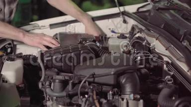 汽车修理工检查汽车发动机机油和空气过滤器检查，以便在车库或汽车修理厂排除故障和修理