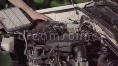 汽车修理工检查汽车发动机机油和空气过滤器检查，以便在车库或汽车修理厂排除故障和修理