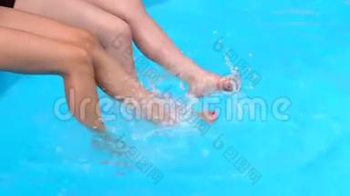 泳池里两个女孩修长的腿特写。