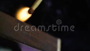 火柴在火柴盒的一侧移动并亮起.. 特写镜头。 浅的景深.. 慢动作。