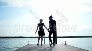 一对情侣牵着对方的手在海岸边散步，一对温柔的情侣在阳光下接吻