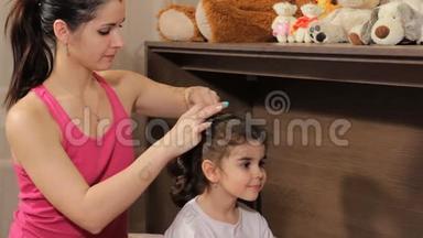 妈妈从美丽的卷发女孩的头上取下一个皱褶。 <strong>为梦想</strong>做准备。