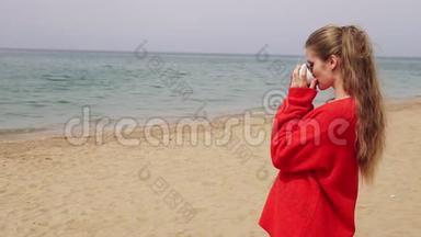 金发女孩在海边的海滩上喝茶
