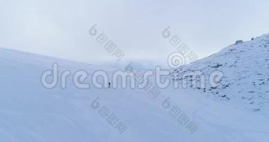 轨道航空飞越冬季雪山滑雪田径场，登山滑雪者走上登山。 雪