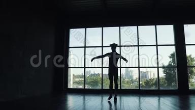 大窗户<strong>背景</strong>上芭蕾舞演员的剪影。 <strong>舞蹈</strong>演员踮起脚尖优雅地移动