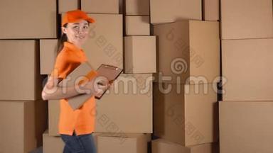 穿着<strong>橙色</strong>制服的苗条女孩背着纸箱堆背送包裹。 4K工作室<strong>视频</strong>