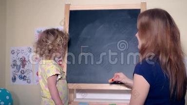 幸福的家庭女孩妈妈和女儿在黑板上写字爸爸