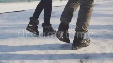 脚穿着追踪鞋在雪地里行走。 朋友们在雪道上散步