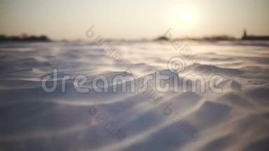 北极风暴。 日落时分的雪暴特写镜头。 风吹雪花，把它们吹过田野