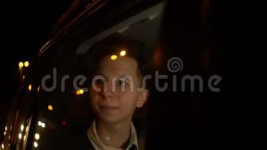 年轻英俊的少年在夜间城市和司机一起乘<strong>坐出租车</strong>旅行的肖像。 4k个镜头