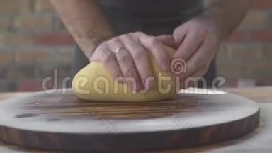 面包师<strong>揉面团</strong>烤面包。 厨师在木桌上做披萨<strong>面团</strong>。 自制糕点制作过程
