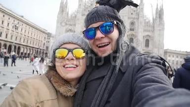 在米兰的多摩大教堂前，快乐的游客拿着一张带电话的自我画像。 冬<strong>季旅游</strong>概念