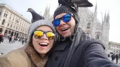 在米兰的多摩大教堂前，快乐的游客拿着一张带电话的自我画像。 冬<strong>季旅游</strong>概念