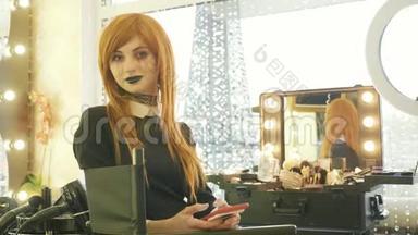 年轻漂亮的女孩在美容院用智能<strong>手机化妆</strong>万圣节
