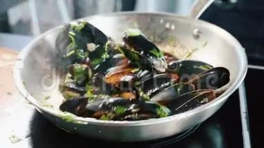 把贻贝放进煎锅里。 厨师将海鲜与油和调料混合