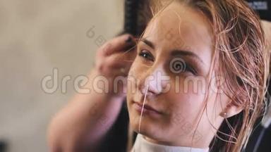 女人，发型师，理发师，模特用白色烘干机`头发，为一个长头发的女人做发型