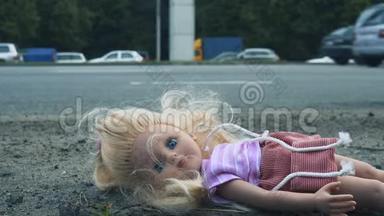 娃娃躺在马路附近，<strong>车水马龙</strong>. 许多汽车从后面来。