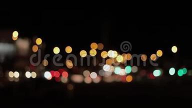 夜晚城市背景的灯光。 城市交通中移动汽车的离焦前灯。 抽象的，明亮的，闪光的，彩色的