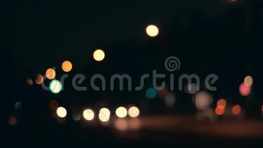 夜晚城市背景的灯光。 城市交通中移动汽车的离焦前灯。 抽象的，明亮的，闪光的，彩色的