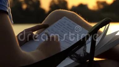 有才华的人在折叠椅上啜泣，并在日落时写在一<strong>本书</strong>上