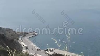 希腊圣托里尼岛的奥莫斯·阿蒂诺斯港。 卡尔德斯火山岛上空的鸟瞰图
