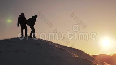 团队合作剪影商务旅行理念.. 2.两个徒步旅行者从登山者手中滑下来，爬到山顶