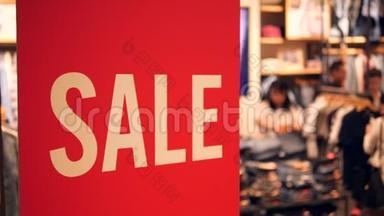 购物中心大红色销售标志。 购买折扣服装的人。 黑色星期五概念。 4K.