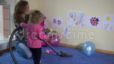 幼儿和幼儿用吸尘器打扫房间..