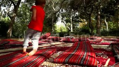 有趣的小男孩在公园里用<strong>地毯</strong>和床<strong>垫</strong>奔跑和欢乐。