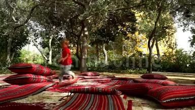 有趣的小男孩在公园里用地毯和床垫奔跑和欢乐。