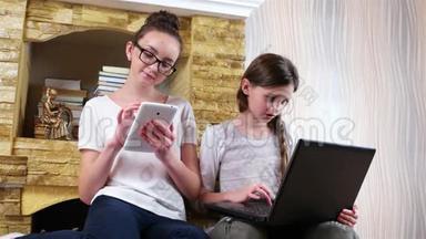 和同学一起做家庭作业，女孩一起坐在地毯上，使用笔记本电脑和平板电脑