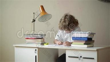 小男孩学习或做家务，小男孩用笔记本和书在桌子上学习