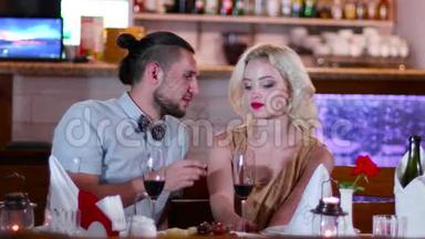 浪漫的气氛在餐厅，年轻的情侣男女在咖啡馆的浪漫约会，迷人的眼睛，美丽