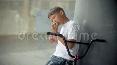 男孩坐在一辆BMX自行车上，吃起来有热狗的<strong>胃口</strong>