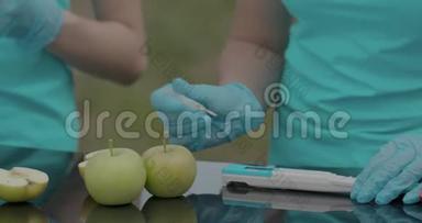 生物学家或农学家通过便携式数字设备测量苹果的酸度。