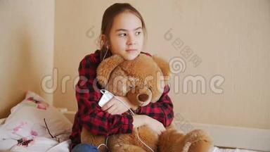 少女与玩具熊<strong>坐在床上</strong>听音乐的慢动作视频
