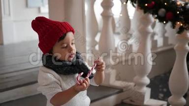孩子们穿着白色毛衣和红色帽子站在雪地里的门廊台阶上