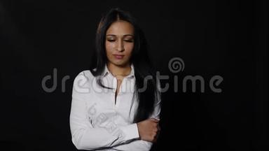 沮丧沮丧的年轻女人看着被隔离在黑色背景上的相机