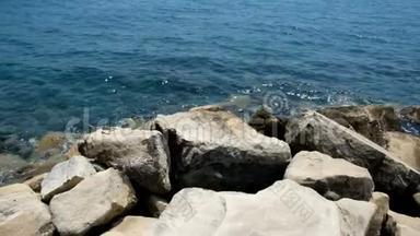 在晴朗的日子里特写一片石滩。 海滩上的<strong>岩石</strong>和鹅卵石，淹没了浪花和<strong>海浪</strong>。