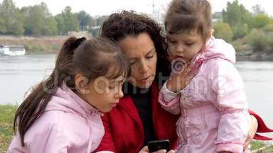 家人<strong>看手机</strong>.. 妈妈用<strong>手机</strong>给两个女儿<strong>看</strong>东西。 背景情况