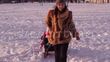 妈妈用雪橇把孩子<strong>卷起</strong>来。