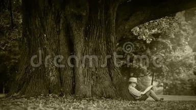 老电影效果片段：一个男孩坐在大<strong>树下看书</strong>