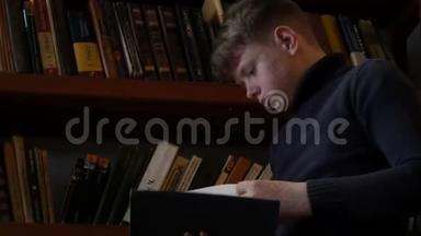 十几岁的男孩在图书馆里阅读一本书，背景是书架上有很多书。