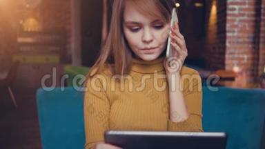 小可爱的女人在咖啡馆里坐着<strong>数码</strong>平板电脑边说着<strong>手机</strong>