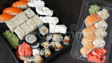 两套大寿司，有很多寿司，<strong>卷</strong>，肉<strong>卷</strong>，黑吉里，甘坎。 黑色木桌上的时尚寿司